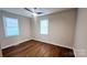 Neutral bedroom features sleek flooring, modern ceiling fan, and lots of natural light at 703 Central Nw Dr, Concord, NC 28027