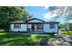 Charming single-story home with white brick, wooden porch, shutters, and well-maintained front lawn at 703 Central Nw Dr, Concord, NC 28027