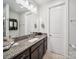 Well-lit bathroom with granite countertop vanity, large mirror, and plenty of storage at 7150 Irongate Dr, Indian Land, SC 29707