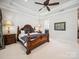 Primary bedroom featuring a decorative trey ceiling, carpet floors, a ceiling fan and bedside lamps at 7150 Irongate Dr, Indian Land, SC 29707