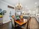 Dining area showcasing an open floor plan with modern kitchen, elegant chandelier and access to outdoor patio at 7150 Irongate Dr, Indian Land, SC 29707
