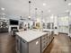 Gourmet kitchen with an oversized island, stainless steel appliances, and open concept to the living area at 7150 Irongate Dr, Indian Land, SC 29707