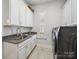 Functional laundry room featuring cabinetry, granite countertops, and modern appliances at 7150 Irongate Dr, Indian Land, SC 29707