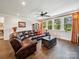 Cozy living room with a leather sectional, hardwood floors, and large windows with natural light at 7150 Irongate Dr, Indian Land, SC 29707