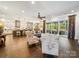 Bright open-concept living room with hardwood floors, kitchen island, and access to outdoor patio at 7150 Irongate Dr, Indian Land, SC 29707