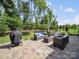 Outdoor patio with cushioned seating, grill, and manicured lawn surrounded by trees at 7150 Irongate Dr, Indian Land, SC 29707