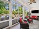 Bright sunroom with large windows overlooking the landscaped backyard and outdoor seating area at 7150 Irongate Dr, Indian Land, SC 29707