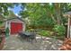 Landscaped backyard with a dining set, brick patio, detached garage and comfortable seating at 726 E Kingston Ave, Charlotte, NC 28203