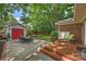 Landscaped backyard with a dining set, brick patio, detached garage and comfortable seating at 726 E Kingston Ave, Charlotte, NC 28203