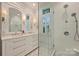 Elegant bathroom with double vanity, white cabinets, marble countertop and glass-enclosed walk in shower at 726 E Kingston Ave, Charlotte, NC 28203