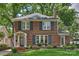 Charming brick home with black shutters, a well-manicured lawn, and a welcoming front porch and walkway at 726 E Kingston Ave, Charlotte, NC 28203