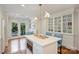 Open kitchen showcasing white cabinetry, hardwood floors, a center island, and easy access to the backyard at 726 E Kingston Ave, Charlotte, NC 28203