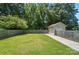 Large backyard featuring a well-maintained lawn, a shed, and a wooden fence, offering privacy at 900 Nance St, Kannapolis, NC 28083