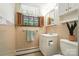 Cozy bathroom with pink tile, a vanity with storage, decorative window shutters, and a toilet at 900 Nance St, Kannapolis, NC 28083