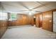 Bedroom with carpeted floors, wood walls, a window AC unit, and an adjacent closet at 900 Nance St, Kannapolis, NC 28083