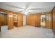 Bedroom with carpeted floors, wood walls, ceiling fan, closet, and an exterior door at 900 Nance St, Kannapolis, NC 28083