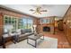 Comfortable living room featuring wood paneled walls, a brick fireplace, and large windows at 900 Nance St, Kannapolis, NC 28083