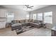 Open concept living room with a large sectional couch, ceiling fan, and many windows at 1010 Harry Ct, Albemarle, NC 28001
