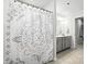 Bathroom featuring a modern shower curtain, double sink vanity with gray cabinets, and neutral wall color at 11246 Bartrams Way, Charlotte, NC 28278