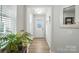 Bright foyer featuring wood floors, white trim, and a view of the front door with sidelights at 11246 Bartrams Way, Charlotte, NC 28278