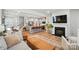 Open-concept living area featuring a fireplace, kitchen island with bar stools, and hardwood floors at 11246 Bartrams Way, Charlotte, NC 28278