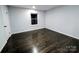 Simple bedroom with dark hardwood flooring, white trim and one window at 11419 Leadenhall Ln, Charlotte, NC 28262