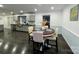 Dining room with dark wood floors, round table, and open access to kitchen at 11419 Leadenhall Ln, Charlotte, NC 28262