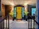 Inviting covered porch featuring a yellow door, black trim, greenery, and outdoor seating at 11419 Leadenhall Ln, Charlotte, NC 28262