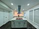Open kitchen with a center island cooktop and stainless steel vent hood at 11419 Leadenhall Ln, Charlotte, NC 28262