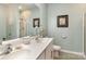 Well-lit bathroom features double sinks with a walk-in shower in the background at 1220 Kent Downs Sw Ave, Concord, NC 28027