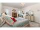 A bright bedroom with carpet features a dresser, armoire, and windows with sheer white curtains at 1220 Kent Downs Sw Ave, Concord, NC 28027