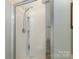 Clean white tiled shower enclosure featuring shampoo storage at 1220 Kent Downs Sw Ave, Concord, NC 28027