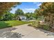 Landscaped backyard with lush lawn, mature trees, a swimming pool, and an outdoor kitchen at 1236 James Farm Rd, Hickory, NC 28602