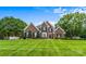 Charming brick home with lush lawn, manicured landscaping, mature trees, and black shutters to accent windows at 1236 James Farm Rd, Hickory, NC 28602