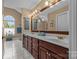Bright main bathroom featuring double vanities, wood cabinets, and large mirror at 1236 James Farm Rd, Hickory, NC 28602