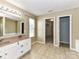 Bathroom featuring double sink vanity, tile flooring, and ample lighting at 14307 Hartwell Farm Dr, Charlotte, NC 28278