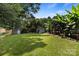 Wide shot of the fenced in back yard, featuring mature trees and storage sheds at 1507 Breckenwood Dr, Rock Hill, SC 29732