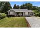 Charming home features a manicured lawn and inviting front porch with classic rocking chairs and wooden shutters at 1507 Breckenwood Dr, Rock Hill, SC 29732