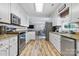 Well-lit kitchen features stainless steel appliances, granite counters, and wood grain flooring with an open view to the dining area at 1507 Breckenwood Dr, Rock Hill, SC 29732