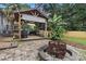 Covered outdoor kitchen and grill area with string lights and a brick fire pit in the yard at 1507 Breckenwood Dr, Rock Hill, SC 29732
