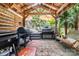 Covered outdoor kitchen with multiple grilling stations, a wooden swing, and adjacent patio at 1507 Breckenwood Dr, Rock Hill, SC 29732