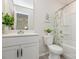 Bright bathroom with a white vanity, toilet, and shower featuring a green-patterned curtain at 1514 Starmount Cove Ln, Charlotte, NC 28210