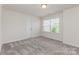 This bedroom features neutral walls, carpeted flooring, and a window bringing in natural light at 1514 Starmount Cove Ln, Charlotte, NC 28210