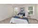 Beautiful bedroom featuring a king-size bed with a blue comforter, side tables, and two windows at 1514 Starmount Cove Ln, Charlotte, NC 28210
