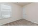 This bedroom features neutral walls, carpeted flooring, and a window bringing in natural light at 1514 Starmount Cove Ln, Charlotte, NC 28210