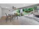 Charming back patio with ceiling fan and view of a lush, green backyard with mature trees and play set at 1744 Emerywood Dr, Charlotte, NC 28210