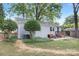 Home's backyard showcasing a patio with seating, lush lawn, mature trees, and a detached garage with a covered area at 1744 Emerywood Dr, Charlotte, NC 28210