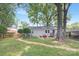 Secluded backyard featuring a detached structure with outdoor space, patio with furniture, and mature trees at 1744 Emerywood Dr, Charlotte, NC 28210