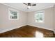 Bright bedroom boasts hardwood floors, two windows, and classic white trim for a clean and inviting feel at 1744 Emerywood Dr, Charlotte, NC 28210