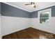 Bright bedroom with wainscoting, hardwood floors, and a ceiling fan providing a comfortable and stylish retreat at 1744 Emerywood Dr, Charlotte, NC 28210